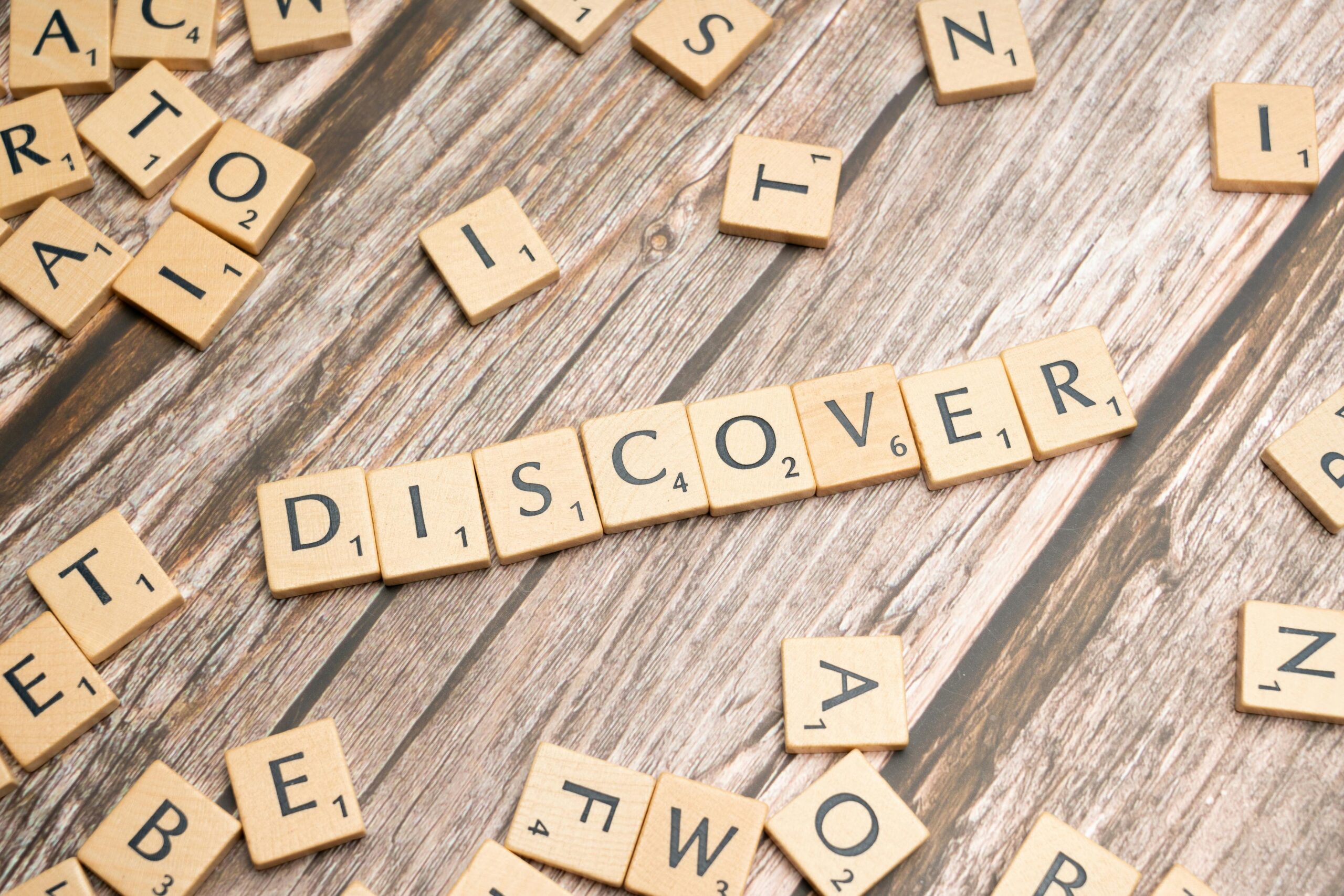 pexels-photo-19802197-19802197 Wooden tiles spelling 'DISCOVER' arranged neatly on a rustic surface.
